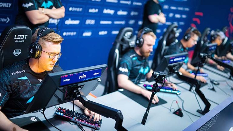 a couple of pro cs2 players playing at a tournament in a sound proof booth