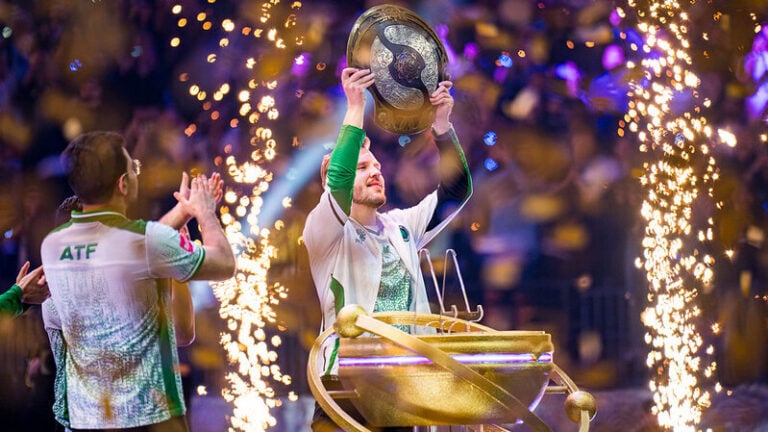 a screenshot that shos Cr1t from Team Falcons lifting the Aegis after TI14